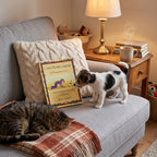 Canine Body Language book on a cosy sofa with a curious puppy and a sleeping cat